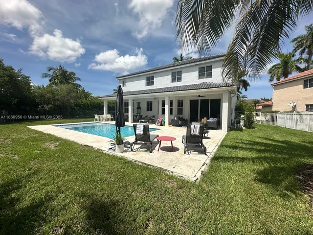 a view of backyard with swimming pool and furniture