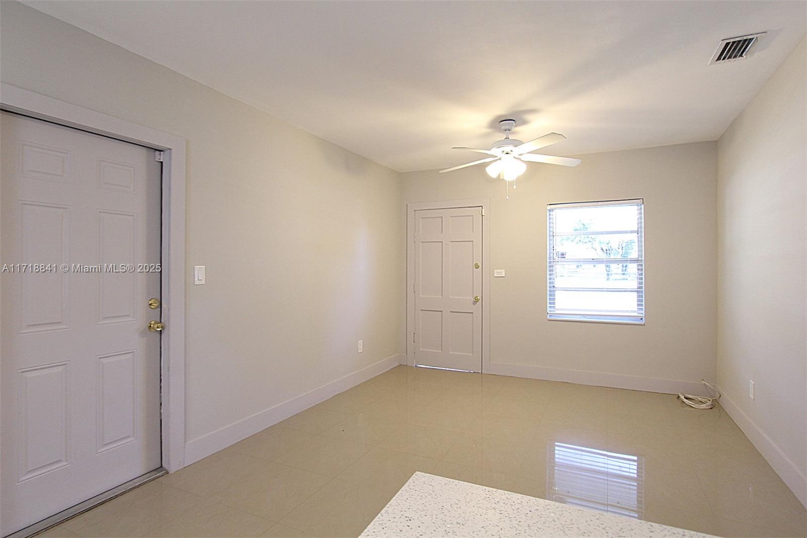 14340 Graves Drive Miami, FL 33176 - Photo 2 of 16 an empty room with windows and ceiling fan