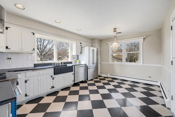 a kitchen with a checkered floor and white cabinets