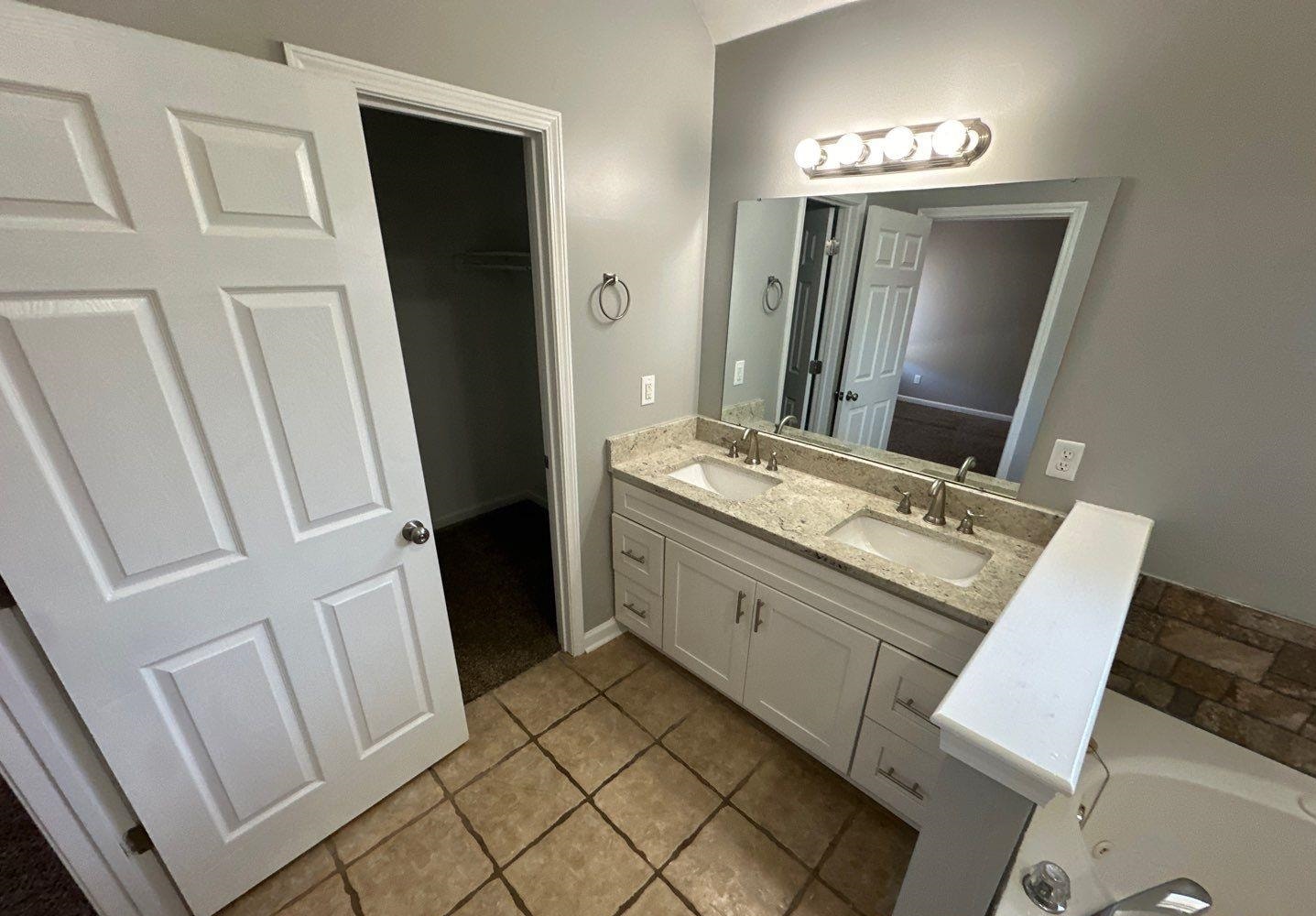 9420 Grove Road Cordova, TN 38016 - Photo 12 of 15 Full bath with double vanity, light tile patterned flooring, and a garden tub