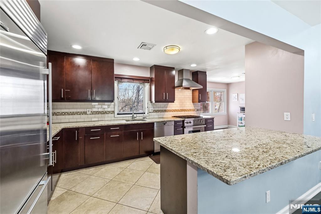 682 Floyd Street Englewood Cliffs, NJ 07632 - Photo 12 of 33 a kitchen with stainless steel appliances granite countertop a sink and a refrigerator