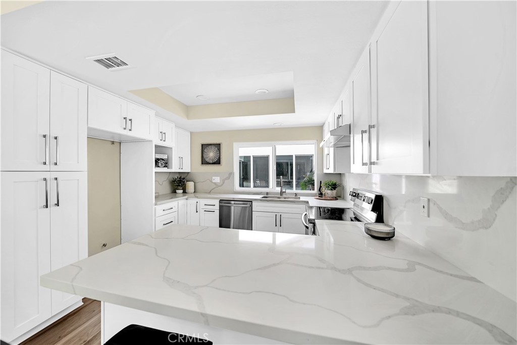 13 Willowbrook Irvine, CA 92604 - Photo 6 of 34 a kitchen with white cabinets and refrigerator