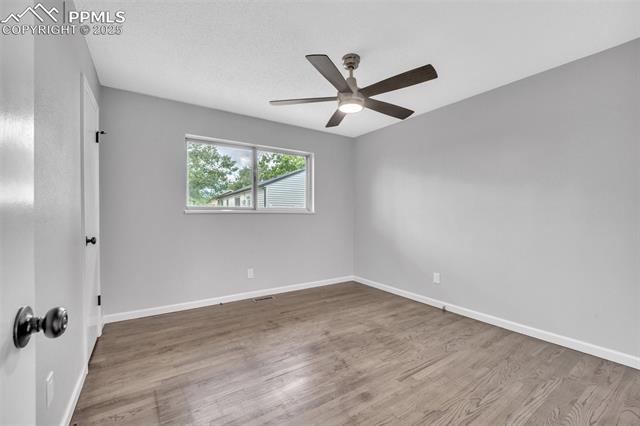 2004 Monterey Road Colorado Springs, CO 80910 - Photo 8 of 27 Spare room featuring a ceiling fan and wood finished floors