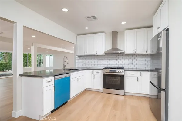 a kitchen with stainless steel appliances granite countertop a stove sink and cabinets
