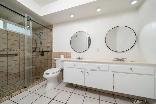 a bathroom with a double vanity sink mirror and toilet