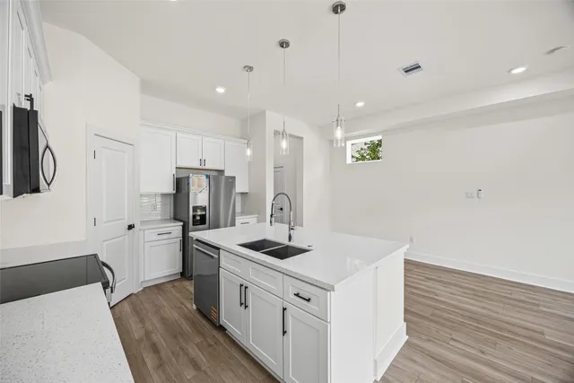 a kitchen with refrigerator cabinets and wooden floor