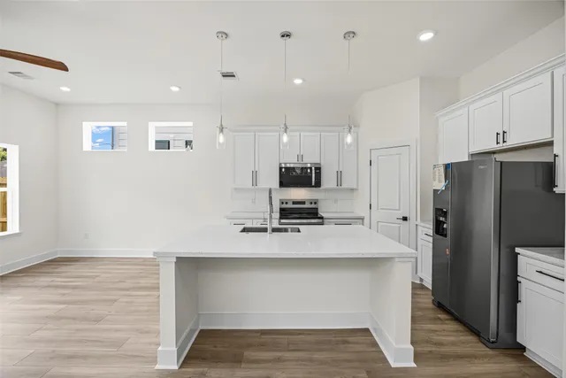 a kitchen with stainless steel appliances a refrigerator sink and microwave
