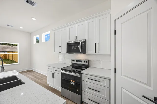 a kitchen with stainless steel appliances a stove a microwave and a refrigerator