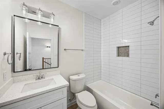 a bathroom with a toilet a sink a mirror and bathtub