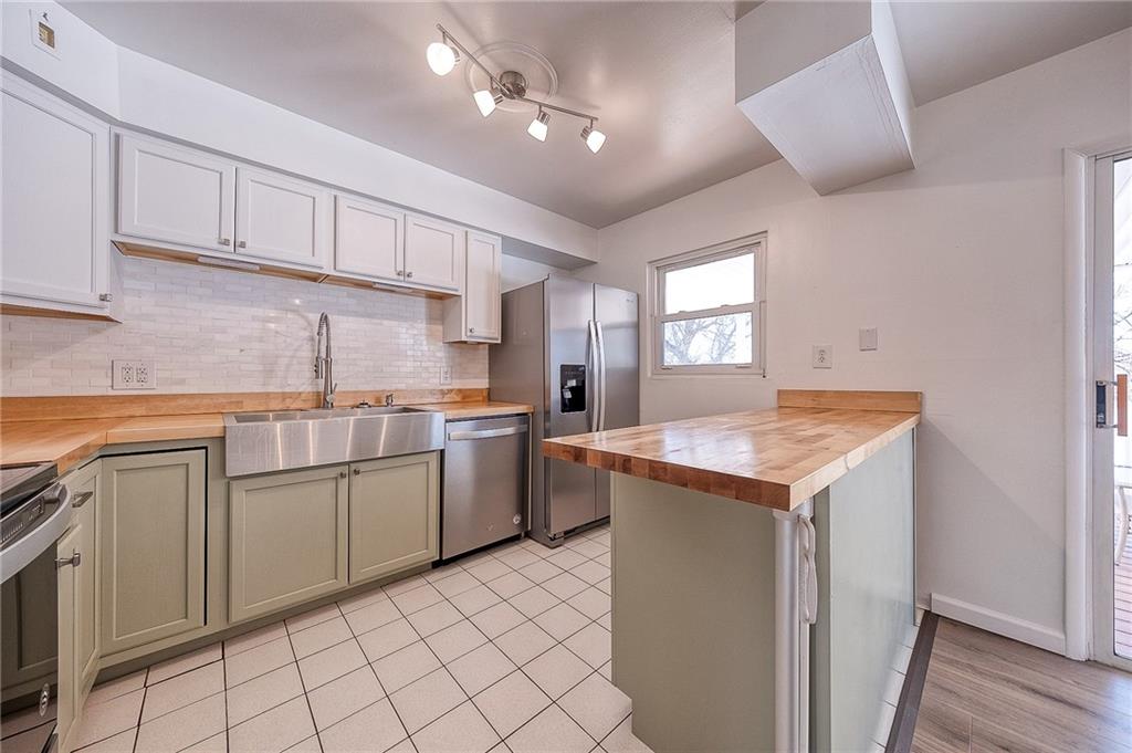9871 Deerfield Drive Irwin, PA 15642 - Photo 2 of 35 a kitchen with a sink window and white cabinets