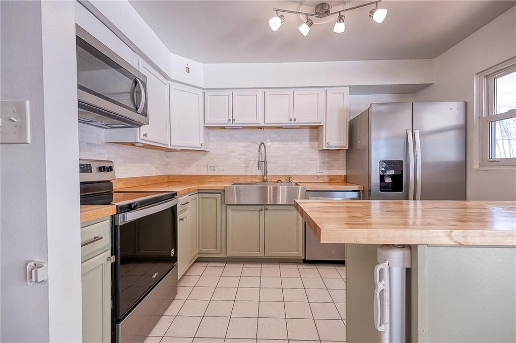 9871 Deerfield Drive Irwin, PA 15642 - Photo 3 of 35 a kitchen with stainless steel appliances granite countertop a stove a sink and a refrigerator