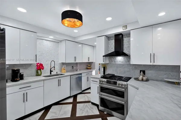 a kitchen with stainless steel appliances kitchen island granite countertop a refrigerator and a stove top oven