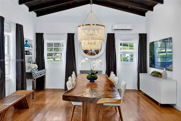 a view of a dining room with furniture a chandelier and wooden floor