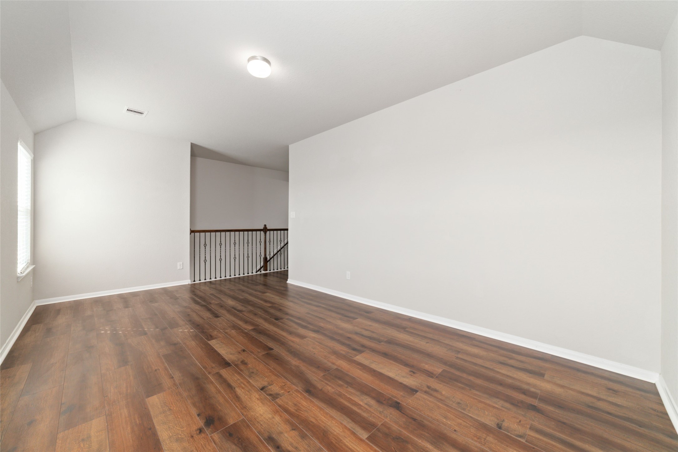 14838 Ruddy Duck Lane Houston, TX 77049 - Photo 19 of 33 Sleek flooring, a modern light fixture, and an open railing add a polished touch, giving the room an inviting look with subtle architectural interest.