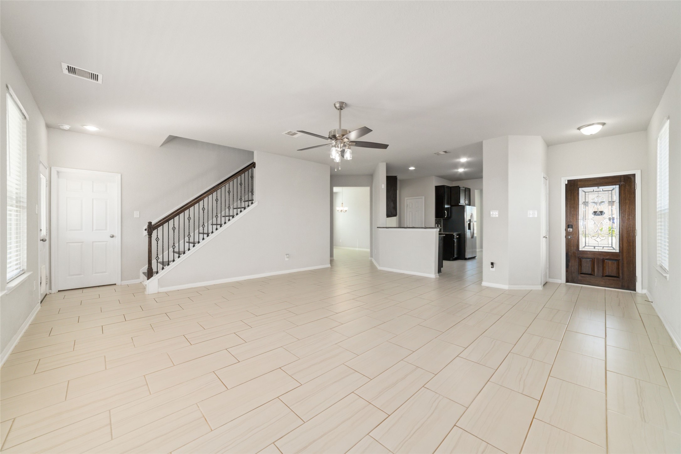 14838 Ruddy Duck Lane Houston, TX 77049 - Photo 5 of 33 This spacious, open-concept living area seamlessly connects to the kitchen and dining area, while a stylish staircase leads to the upper level. The inviting front entry has a decorative wooden door with glass inlay.
