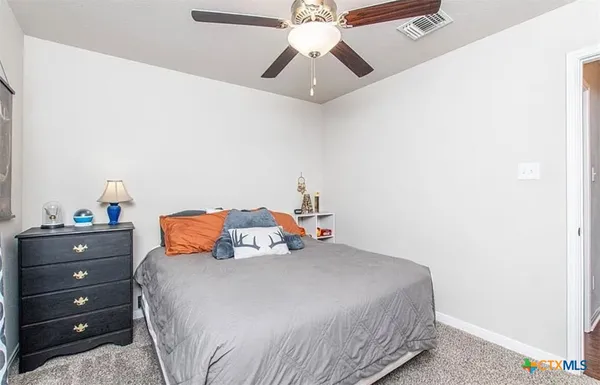 a bedroom with a bed and a chandelier fan