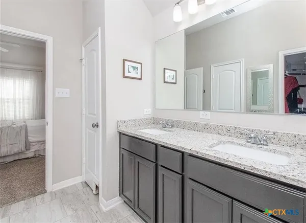 a bathroom with a granite countertop sink and a mirror