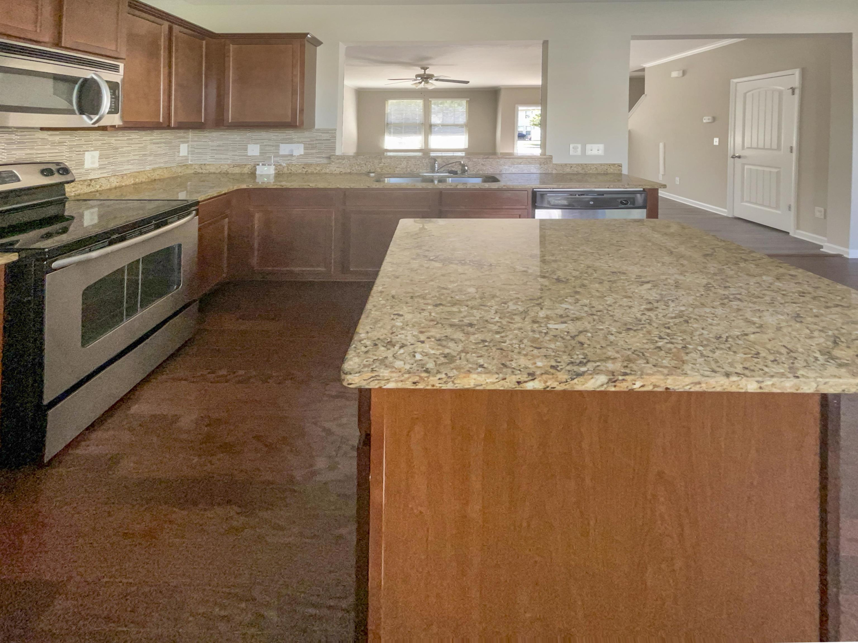 4445 Iyar Way Wake Forest, NC 27587 - Photo 17 of 17 a kitchen with kitchen island granite countertop a sink window and stainless steel appliances