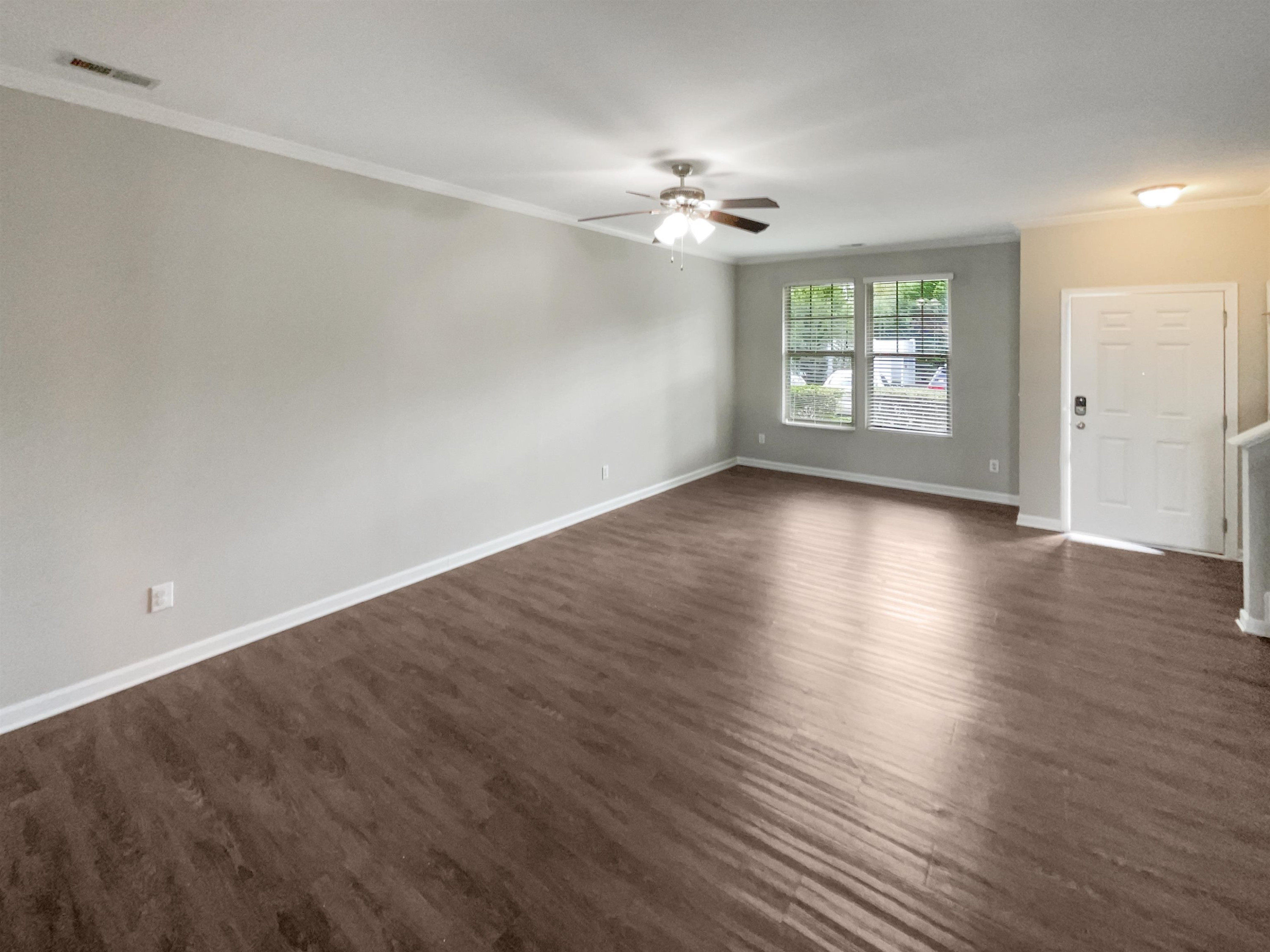 4445 Iyar Way Wake Forest, NC 27587 - Photo 3 of 17 an empty room with wooden floor chandelier fan and windows
