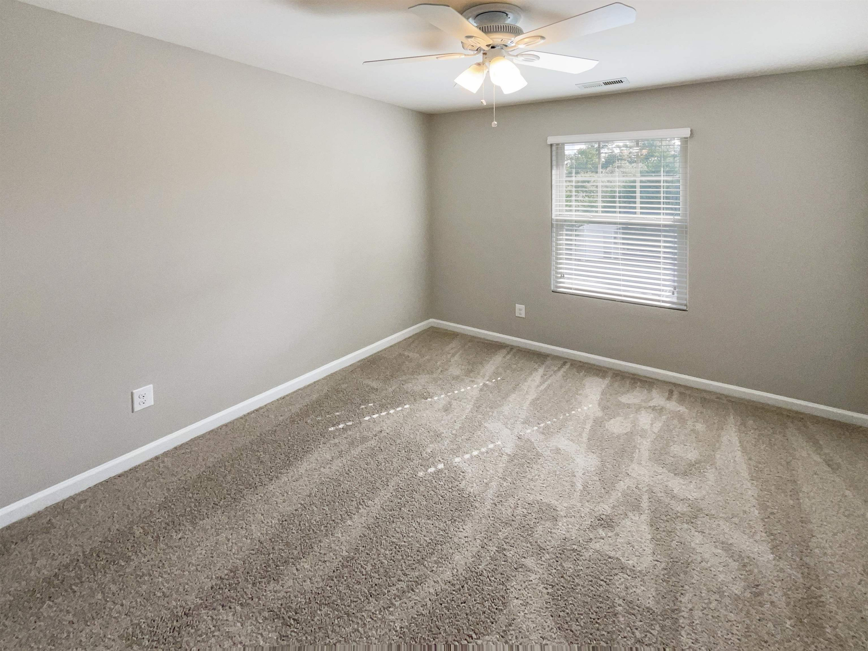 4445 Iyar Way Wake Forest, NC 27587 - Photo 5 of 17 an empty room with a chandelier fan and windows