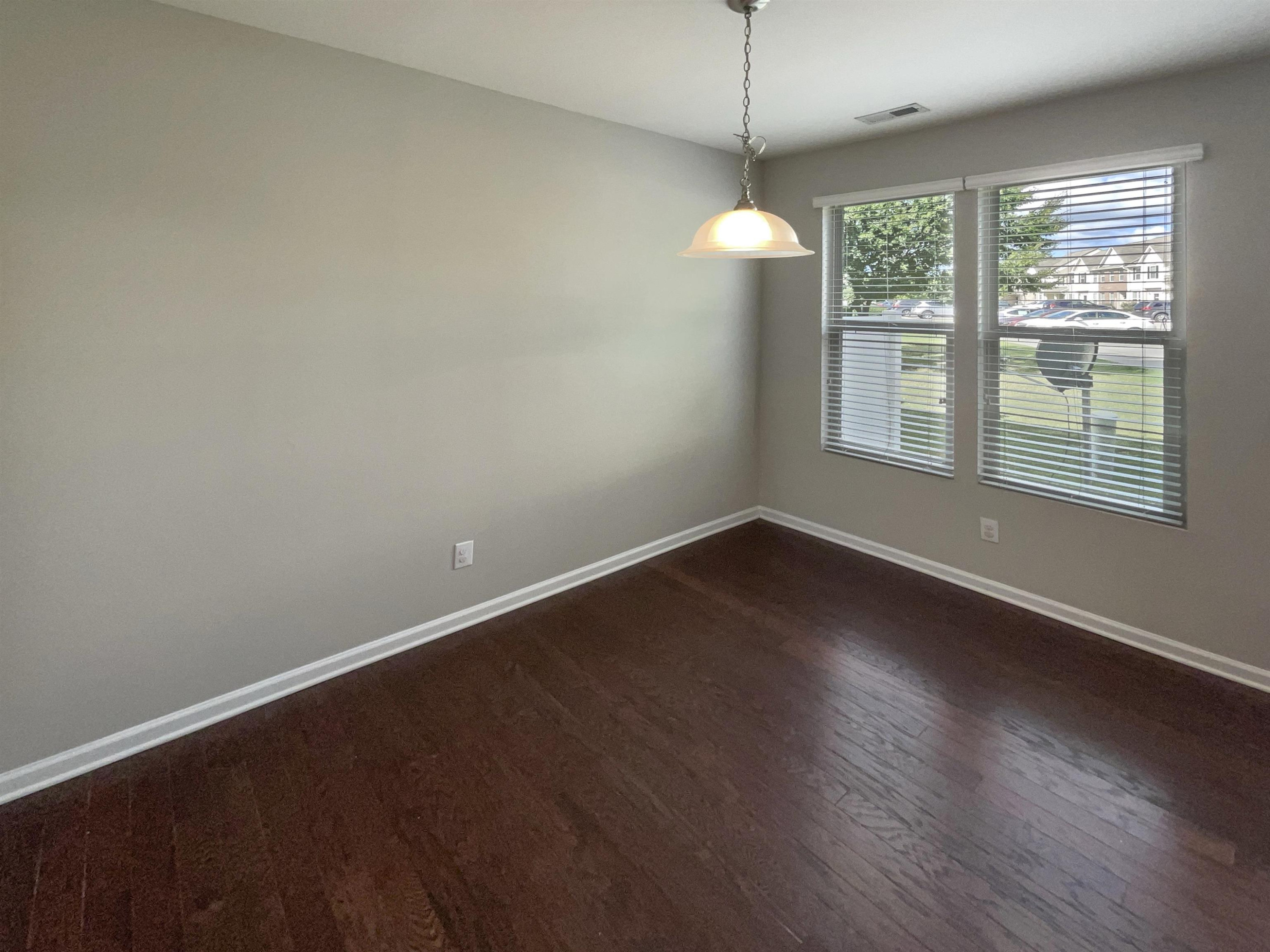 4445 Iyar Way Wake Forest, NC 27587 - Photo 8 of 17 an empty room with wooden floor and windows