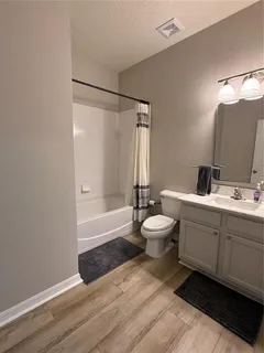 a bathroom with a double vanity sink toilet mirror and shower