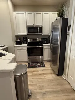 a kitchen with a refrigerator a stove a microwave and cabinets