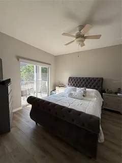 a spacious bedroom with a bed and wooden floor