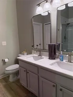 a bathroom with double sink and a toilet