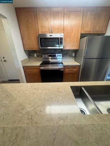 a kitchen with a refrigerator and a stove top oven