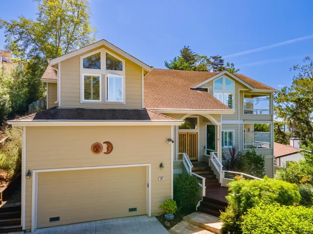 a front view of a house with a tree