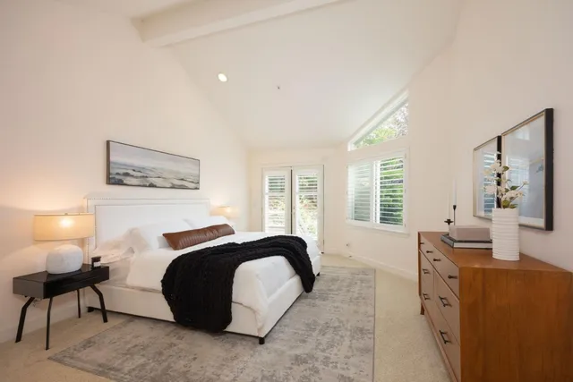 a bedroom with a large window and a bed