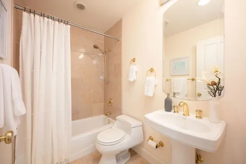 a bathroom with a granite countertop sink a toilet and shower