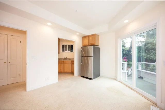 a view of empty room with a kitchen