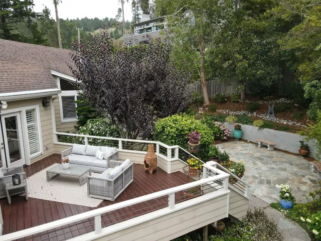 a view of a backyard with chairs and a garden