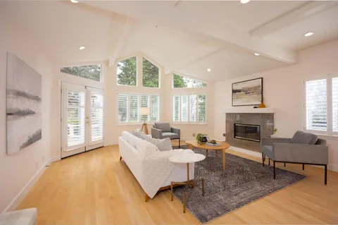 a living room with fireplace furniture and a large window