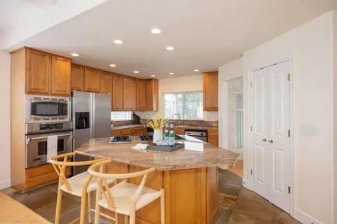 a kitchen with granite countertop a table chairs and wooden floor