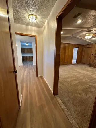 a view of a hallway with wooden floor and staircase