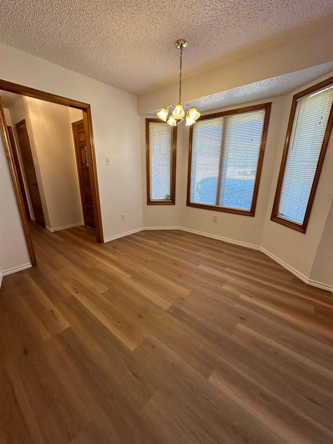 5609 88th Street Lubbock, TX 79424 - Photo 4 of 21 a view of an empty room with window and wooden floor