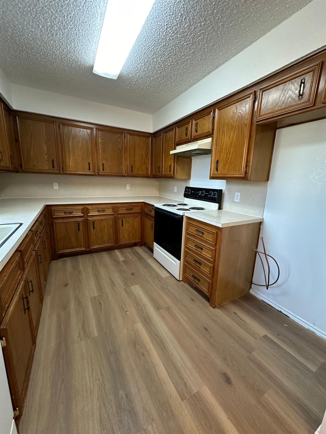 5609 88th Street Lubbock, TX 79424 - Photo 6 of 21 a kitchen with stainless steel appliances granite countertop a sink dishwasher stove and cabinets with wooden floor