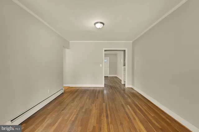 a view of empty room with wooden floor