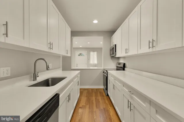 a kitchen with sink a stove and cabinets