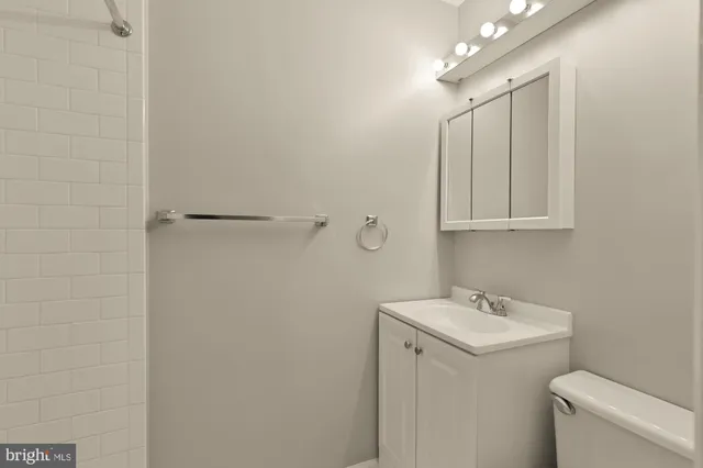 a bathroom with a sink and mirror with toilet