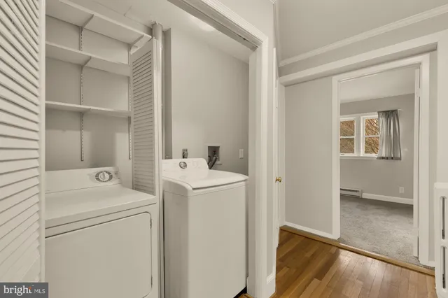 a view of washer and dryer with bathroom in the background