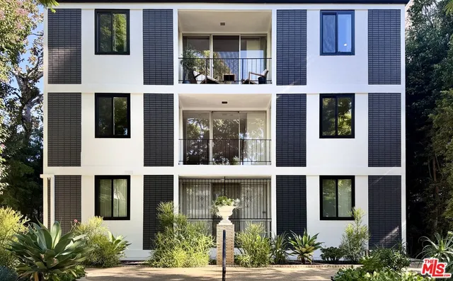 a front view of a building with a garden