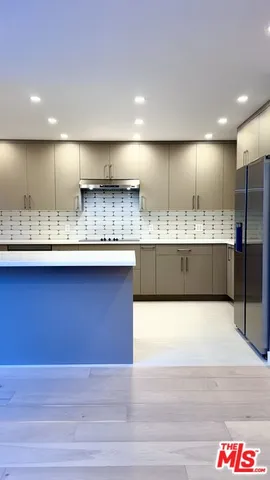 a view of kitchen with kitchen island a sink stainless steel appliances and cabinets