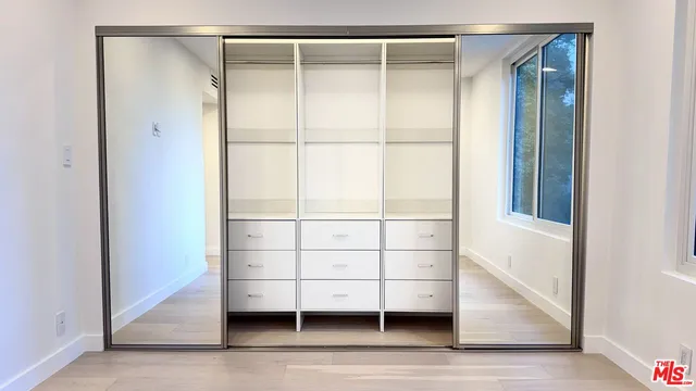 a view of walk in closet with empty racks