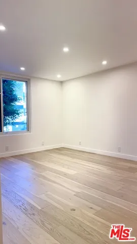 an empty room with wooden floor and window