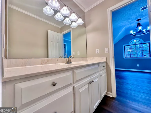 a bathroom with a sink a large mirror and vanity