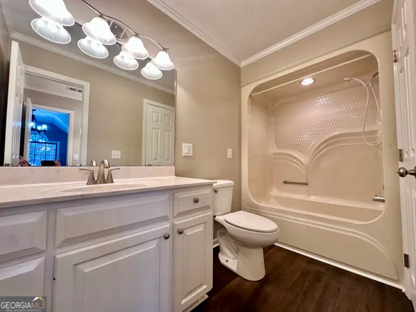 a bathroom with a sink a toilet a large mirror and shower
